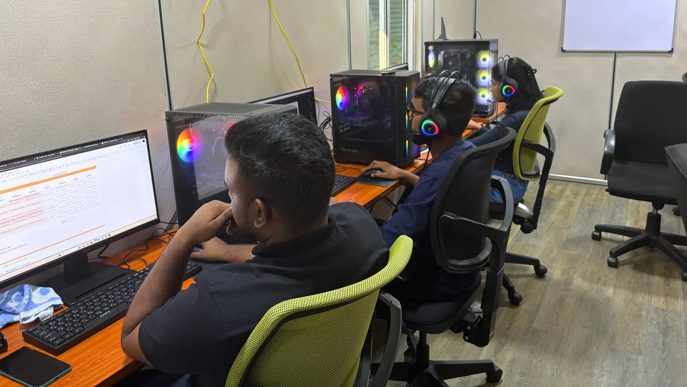 Three of the old production team editing at desktop workstations in the Colombo office.